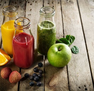 Tasty colorful fresh homemade smoothies in glass jars on wooden