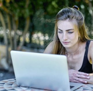 young woman outdoor in a garden with a laptop