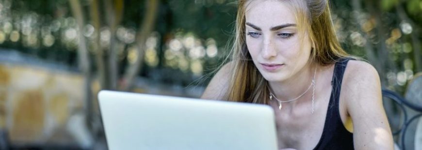 young woman outdoor in a garden with a laptop